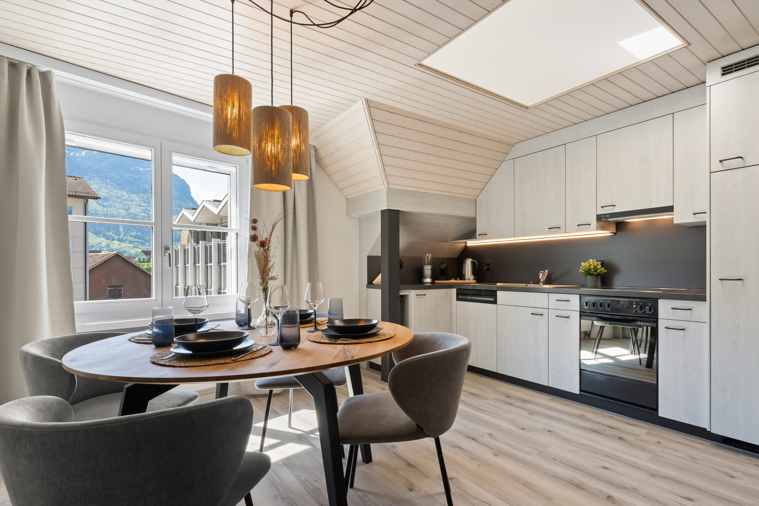Modern dining area inside an Interalps holiday apartment near Lake Lucerne and Andermatt, with warm lighting and Alpine views that reflect Swiss hospitality and comfort.
