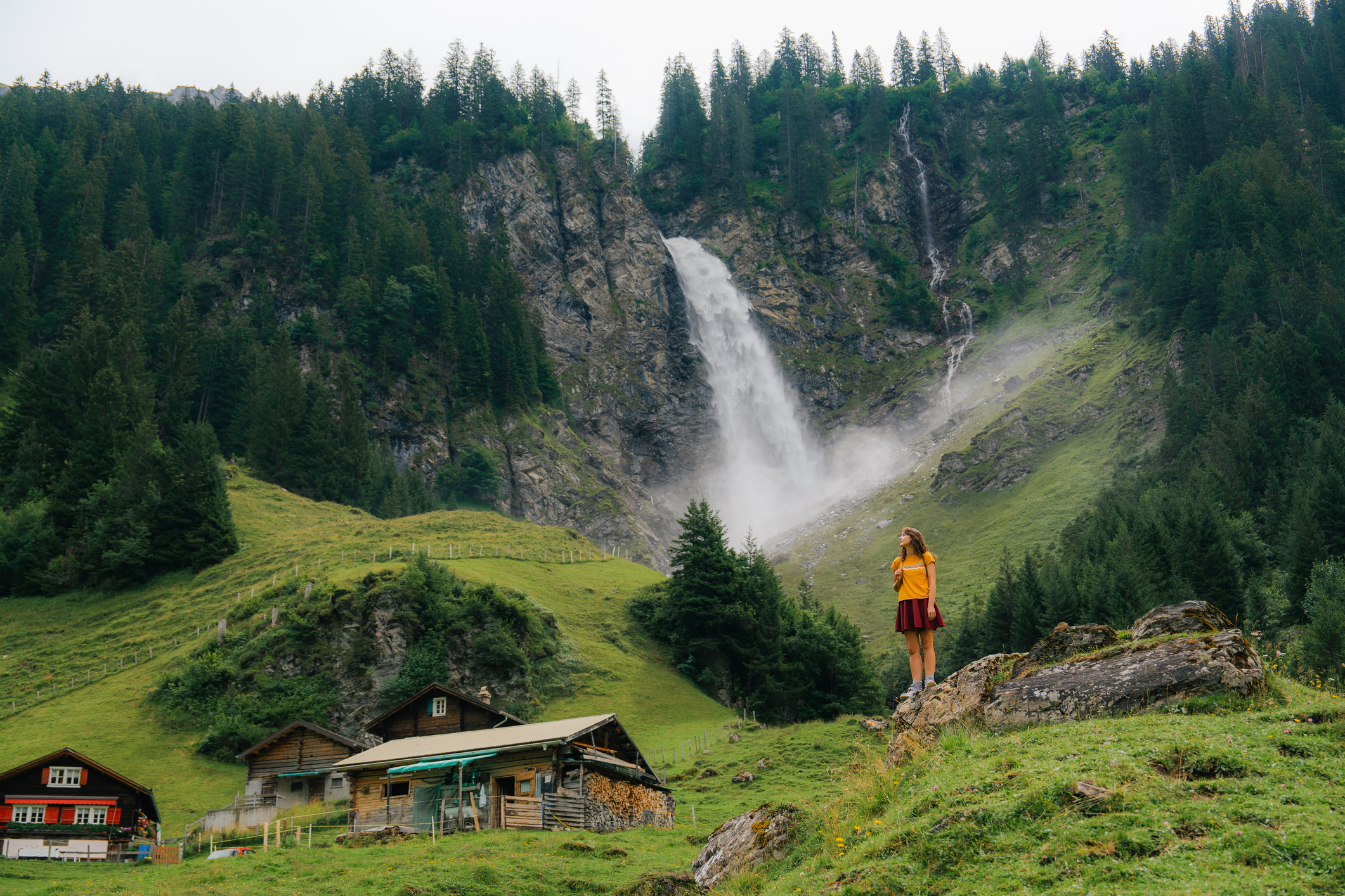 Traveler enjoying the Reichenbach-style Swiss waterfall landscape near Andermatt, representing Interalps’ personalized travel planning service.
